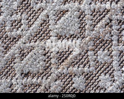 Detail of decorative patterns on a white woven fabric rug Stock Photo
