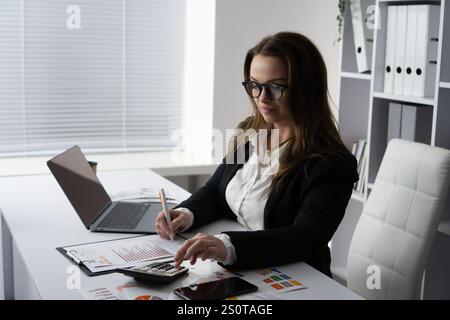 A hardworking business professional engages in analytical tasks at their organized desk, using tools and methods to boost productivity and achieve Stock Photo