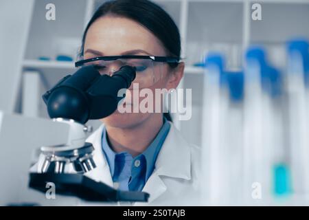 A dedicated scientist meticulously analyzing a specimen through a microscope in a stateoftheart modern laboratory, contributing significantly to the Stock Photo
