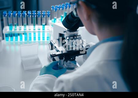 A scientist is meticulously examining various samples under a highpowered microscope in a wellequipped laboratory setting, where groundbreaking Stock Photo