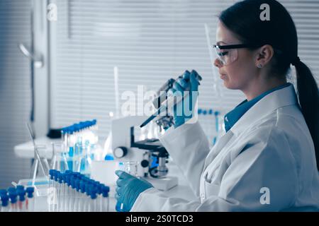 A Research Scientist is meticulously analyzing various samples in a cuttingedge, hightech laboratory equipped with the latest technology to advance Stock Photo