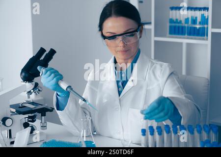 Laboratory Research A dedicated scientist is meticulously conducting various experiments using a micropipette and an array of test tubes to advance Stock Photo