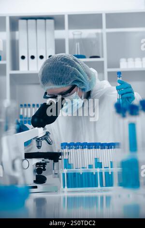 In a thoroughly modern laboratory setting, a dedicated scientist is carefully analyzing various samples under a highquality microscope, performing Stock Photo