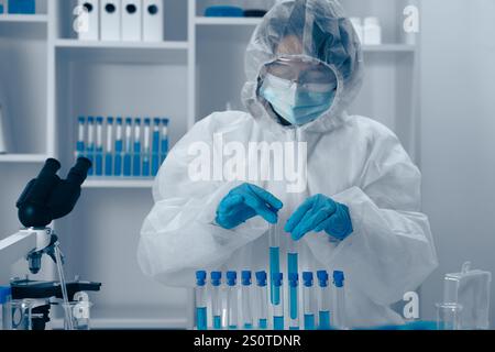 A dedicated scientist is seen in a laboratory where they are conducting various experiments with a collection of test tubes, meticulously analyzing Stock Photo