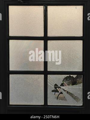 Shattered Perspective: Framed Park Bench Through Broken Glass Stock Photo