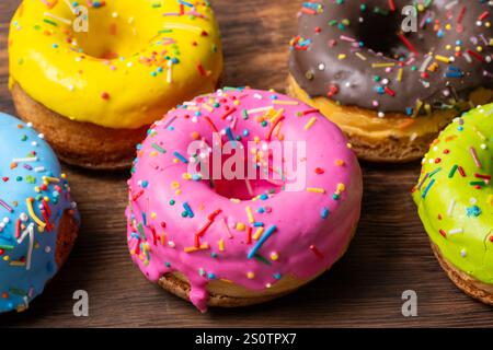 Colorful donuts on wooden background. Closeup Stock Photo