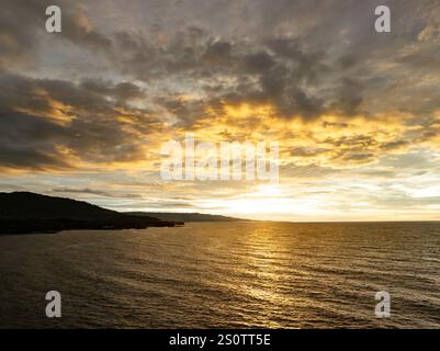 A beautiful and colorful sunset occurs over the Pacific Ocean near Manado, North Sulawesi, Indonesia. This area is a popular destination for diving. Stock Photo