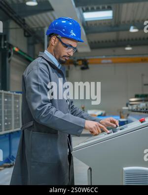 Male engineer working in production line and monitoring automating industrial processes. Stock Photo