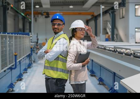 Portrait of female manager engineer and industry worker in manufacture factory. Stock Photo