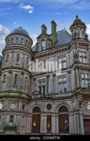 A weathered, grey stone building with multiple towers, arched windows, and a dome.  The architecture is ornate, exhibiting classical features. The bui Stock Photo