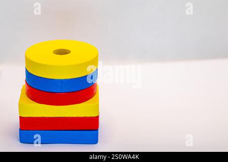 A stack of six colorful wooden blocks on a white background. The blocks are yellow, blue, and red, and are arranged in a pattern.  The top block is a Stock Photo