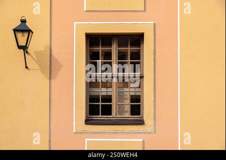 Rectangular window with a fine mesh frame against an orange wall. From the series of windows of the World. Stock Photo