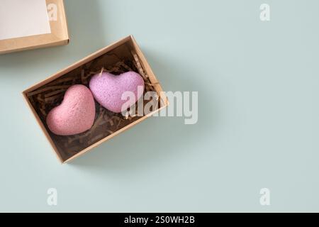 Valentine's Day two heart shaped bathroom bombs in natural gift box on blue background. Handmade bathroom bombs in heart-shaped gift box. Natural cosm Stock Photo