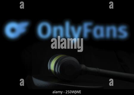 Court gavel in front of the OnlyFans logo. OnlyFans is an internet