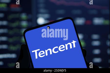 Tencent logo is displayed on smartphone. Tencent Holdings Ltd is a Chinese multinational technology conglomerate and holding company. Stock Photo