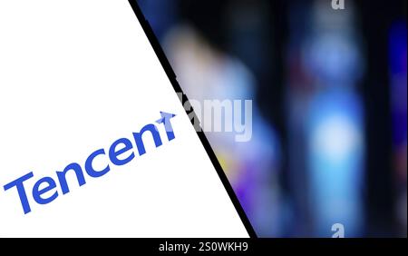 Tencent logo is displayed on smartphone. Tencent Holdings Ltd is a Chinese multinational technology conglomerate and holding company. Stock Photo