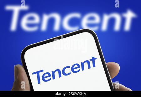 Tencent logo is displayed on smartphone. Tencent Holdings Ltd is a Chinese multinational technology conglomerate and holding company. Stock Photo