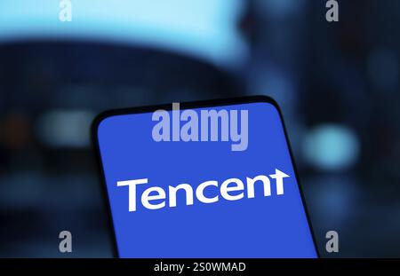 Tencent logo is displayed on smartphone. Tencent Holdings Ltd is a Chinese multinational technology conglomerate and holding company. Stock Photo