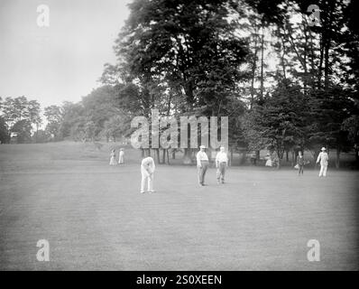 Allan Lard, amateur golfer, putting while playing golf at the Chevy Chase Golf Club, Maryland on June 12, 1909. President William Howard Taft, Vice President James Sherman and amateur golfer Walter Travis are seen in the background. Stock Photo