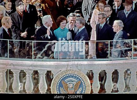 United States President Jimmy Carter is sworn-in as the 39th President of the United States by the Chief Justice of the United States Warren Berger on the East Front of the US Capitol in Washington, DC on January 20, 1977. Also pictured, from left to right: Former US President Gerald R. Ford, US Senator Hubert H. Humphrey (Democrat of Minnesota), first lady Rosalynn Carter, US Vice President Walter Mondale, former US Vice President Nelson Rockefeller, and US Secretary of State Cyrus Vance. Credit: Arnie Sachs/CNP Stock Photo