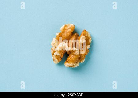 Top view of half walnut kernel on blue background Stock Photo