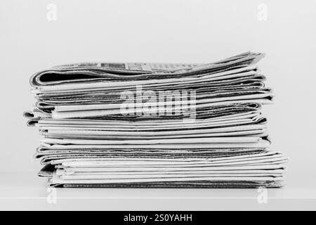 a large stack of newspapers on the table is a black and white photo Stock Photo