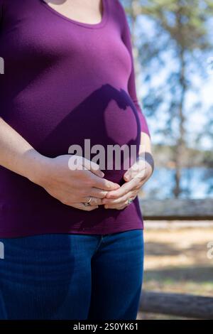 Hands cast a shadow of a heart on pregnant womans belly Stock Photo - Alamy