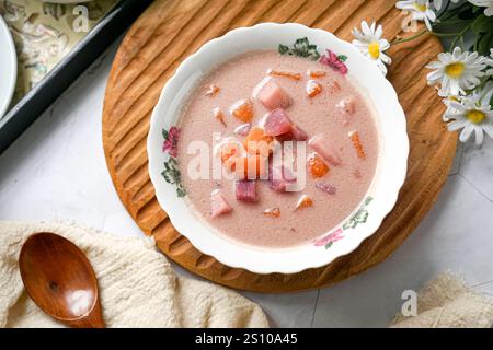 Bubur Cha Cha is a creamy coconut dessert with colorful cubes of purple, orange, and white sweet potatoes and yam. Stock Photo