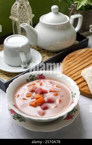 Bubur Cha Cha is a creamy coconut dessert with colorful cubes of purple, orange, and white sweet potatoes and yam. Stock Photo