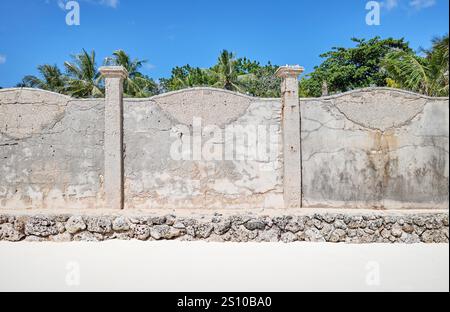 Old cracked concrete fence by a beach. Stock Photo