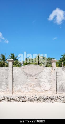 Old cracked concrete fence by a beach. Stock Photo