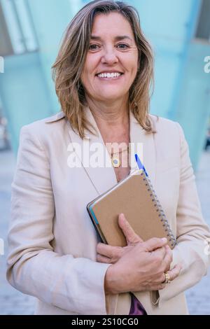Smiling Businesswoman Holding Notebook Outdoors.Vertical Stock Photo