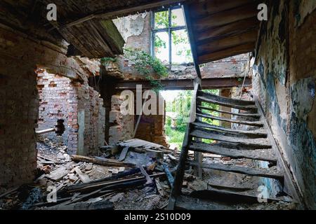 Depressing interior with stairs of an old destroyed and burned down abandoned house Stock Photo