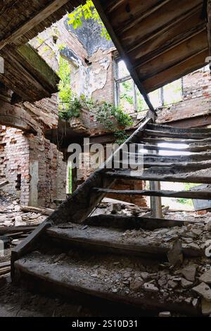 Interior with stairs of an old destroyed and burned down abandoned house Stock Photo
