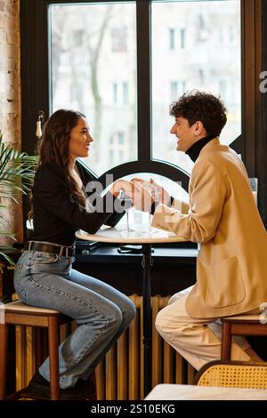 A couple enjoys an intimate Valentines Day dinner, sharing smiles and love over drinks. Stock Photo