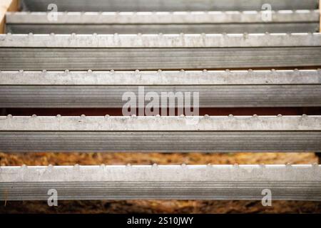 Metal stair step. It consists of several horizontal, parallel metal bars that serve as steps. The rods are placed at a short distance from each other. Stock Photo