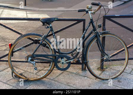 Paris, France, 12.26.2024. A very rusty bike attached to the railing in Paris Stock Photo