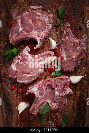 Raw calf meat, meat on the bone, meat for barbecue, cutting board, with spices and herbs, top view Stock Photo