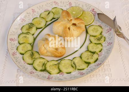 Southern German cuisine, trout cream in puff pastry, starter, fish dish, baked, from the oven, served on a plate, cucumber, lime slices, fish cutlery Stock Photo