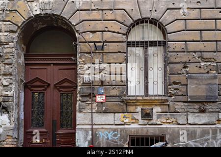 Budapest, Hungary - Sept. 12, 2024:  Old apartment building preserving bullet holes from the 1956 uprising against the Russians Stock Photo