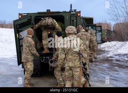 U.S. Army Soldiers of the 1st Battalion, 501st Parachute Infantry Regiment, 11th Airborne Division convoy in CATVs along the route connecting Malamute DZ and Neibhur DZ. Stock Photo