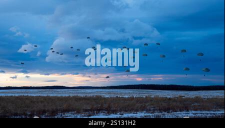 U.S. Army Soldiers of the 1st Battalion, 501st Parachute Infantry Regiment, 11th Airborne Division descend into Malamute DZ, marking the beginning  of a two day training operation called Geronimo Storm. Stock Photo