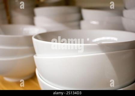 A view of several white ceramic bowls on a pantry shelf. Stock Photo