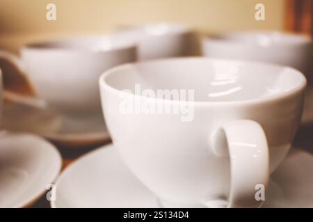 A view of several white ceramic coffee mugs on a shelf in the pantry. Stock Photo