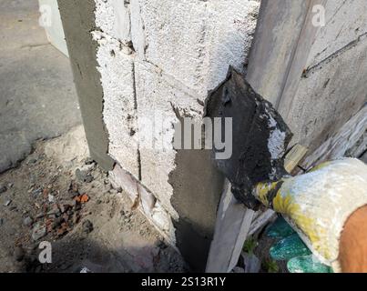Plastering a wall corner using a rule and a spatula Stock Photo