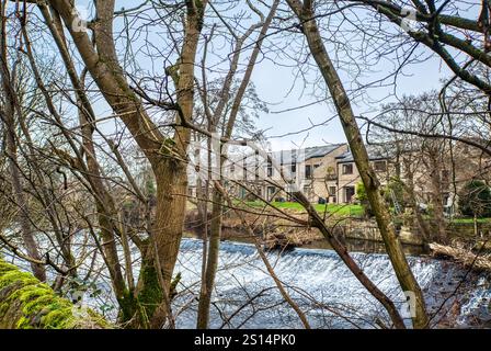 Water tumbling over the old mill weir on the River Derwent at Baslow, Derbyshire, UK Stock Photo