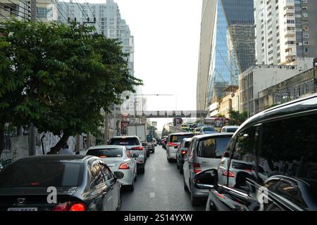 Bangkok, Thailand, Nov 20, 2024: Traffic moves slowly along a busy road cowded traffic jam road in city. Empty fast speed dedicated bus lane Bangkok, Stock Photo