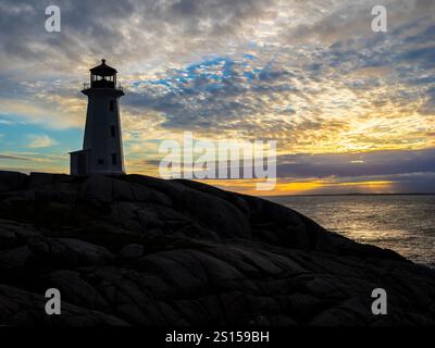 Sunset at Peggys Point Lighthouse also known as  Peggys Cove Lighthouse at the eastern entrance of St. Margarets Bay in Peggys Cove Nova Scotia Canada Stock Photo