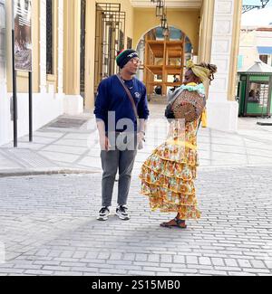 Havana, Cuba, November 23,2024: A street vendorchats with a tourist  in a Havana Cuba street. Patsy Lynch Stock Photo