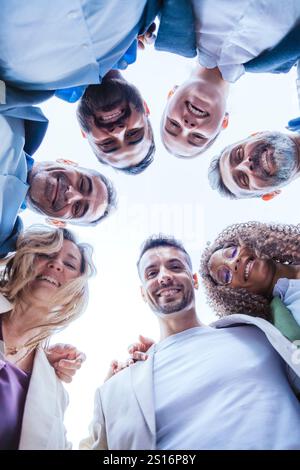 Diverse Team Smiling in a Circle, Bottom View.Vertical Stock Photo
